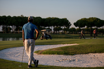 Image showing golfer from back at course looking to hole in distance