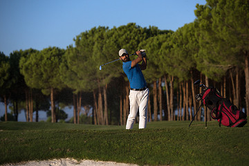 Image showing golfer hitting a sand bunker shot on sunset