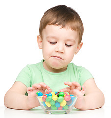 Image showing Portrait of a sad little boy with candies