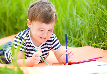 Image showing Little boy is playing with pencils