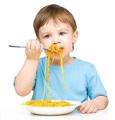 Image showing Little boy is eating spaghetti