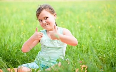 Image showing Little girl is showing thumb up gesture