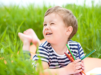 Image showing Little boy is playing with pencils