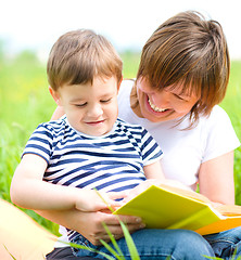 Image showing Mother is reading book for her child