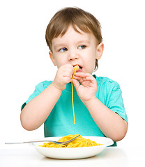 Image showing Little boy is eating spaghetti