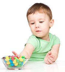 Image showing Little boy refusing to eat candies
