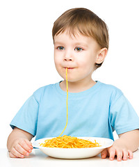 Image showing Little boy is eating spaghetti