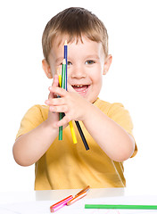 Image showing Little boy is playing with color pencils
