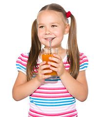 Image showing Little girl is drinking carrot juice