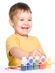 Image showing Little boy is playing with paints