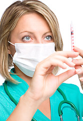 Image showing Young nurse is preparing syringe for injection