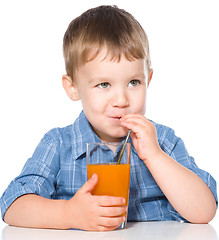 Image showing Little boy with glass of carrot juice