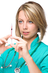 Image showing Young nurse is preparing syringe for injection