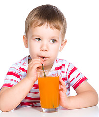 Image showing Little boy with glass of carrot juice