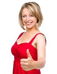 Image showing Woman is showing thumb up gesture