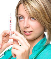 Image showing Young nurse is preparing syringe for injection