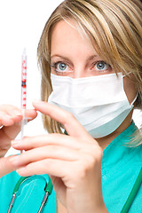 Image showing Young nurse is preparing syringe for injection