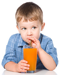 Image showing Little boy with glass of carrot juice