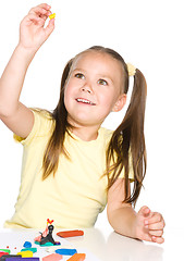 Image showing Little girl is playing with plasticine