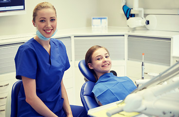 Image showing happy female dentist with patient girl at clinic