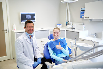 Image showing happy male dentist with woman patient at clinic