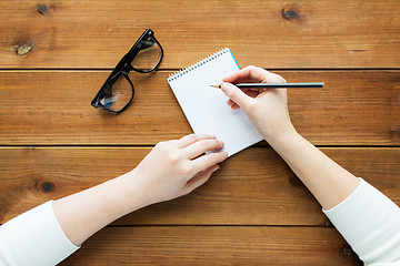 Image showing close up of woman or student writing to notepad