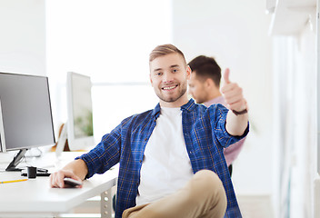 Image showing happy creative man with computer at office