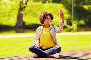 Image showing happy african woman taking selfie with smartphone