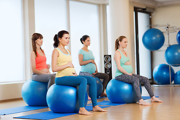 Image showing happy pregnant women exercising on fitball in gym