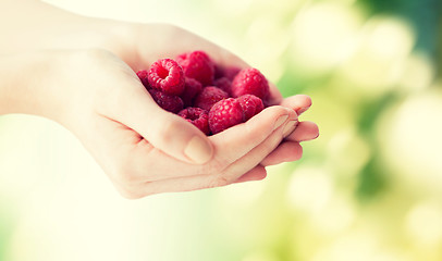 Image showing close up of woman hands holding raspberries