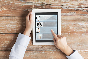 Image showing close up of male hands showing blog on tablet pc