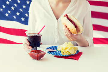 Image showing close up of woman eating hot dog with cola