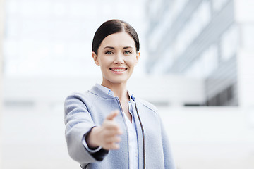 Image showing smiling businesswoman giving hand for handshake