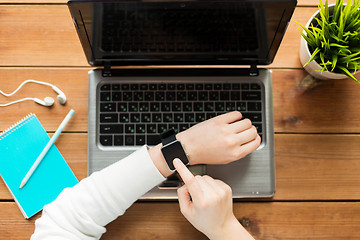 Image showing close up of woman with smart watch and laptop