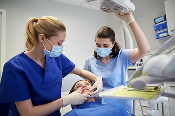 Image showing happy female dentist with patient girl at clinic