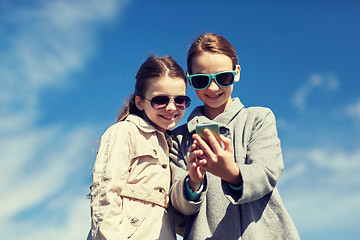 Image showing happy girls with smartphone taking selfie outdoors