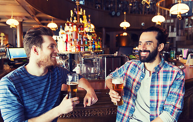 Image showing happy male friends drinking beer at bar or pub