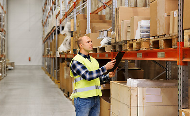 Image showing man with clipboard in safety vest at warehouse