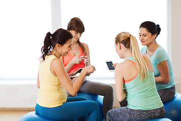 Image showing happy pregnant women with gadgets in gym