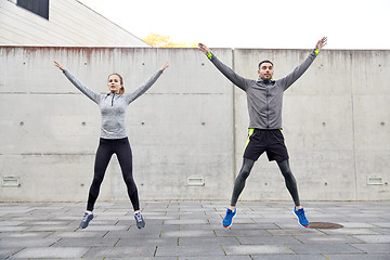 Image showing happy man and woman jumping outdoors