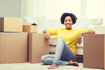 Image showing happy african woman with cardboard boxes at home