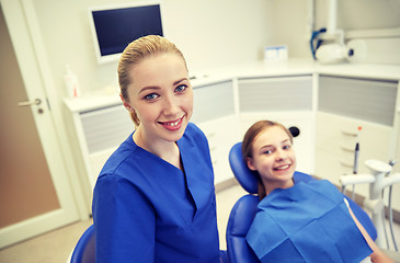 Image showing happy female dentist with patient girl at clinic