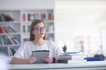 Image showing female student study in school library, using tablet