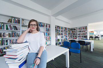 Image showing female student study in library, using tablet and searching for 