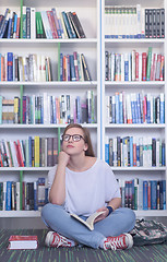 Image showing famale student reading book in library