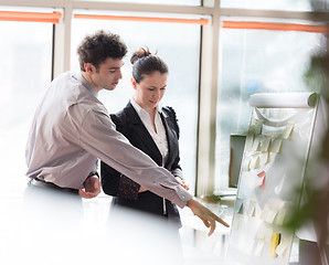 Image showing young couple working on flip board at office