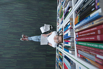 Image showing female student study in library, using tablet and searching for 