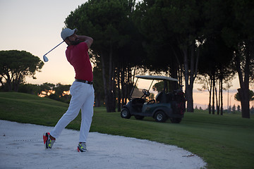 Image showing golfer hitting a sand bunker shot on sunset