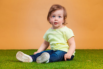 Image showing One cute baby girl on orange background