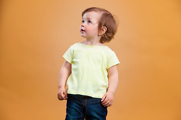 Image showing One cute baby girl on orange background